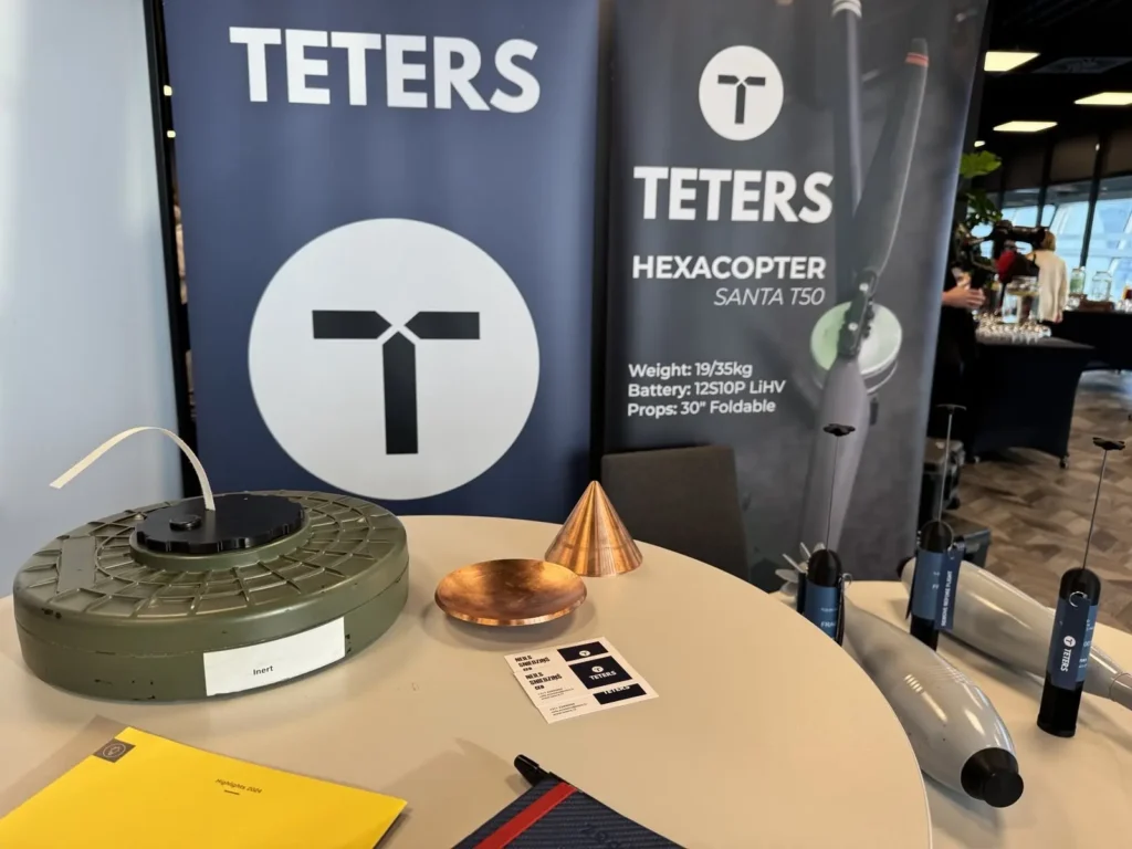 TETERS defense equipment display featuring a land mine, shaped charge components, and the TETERS RX-30 UXO disposal system at Latvian National Armed Forces Industry Day 2026 in Riga